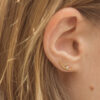 Mulher usando Brinco minimalista com diamantes feito a mão em ouro 18k martelado usado como ear cuff