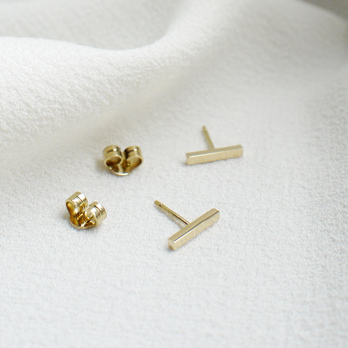Brinco formato reto como uma barrinha minimalista feito a mão em ouro 18k e tarraxa