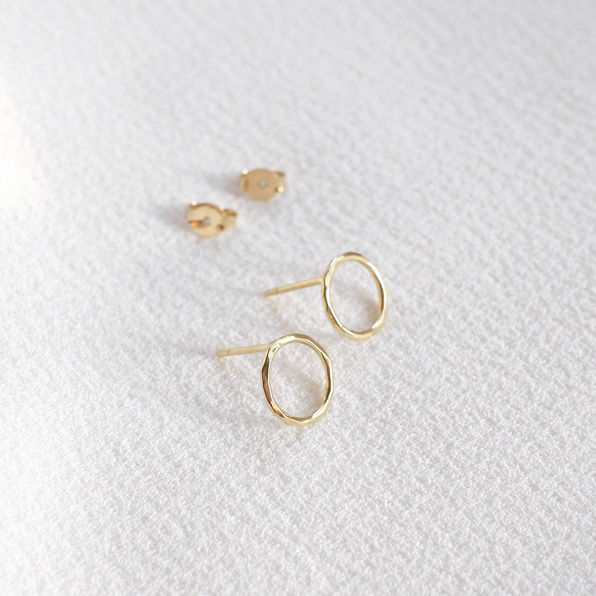 Brinco minimalista em forma de círculo vazado feito a mão em ouro 18k com textura martelada