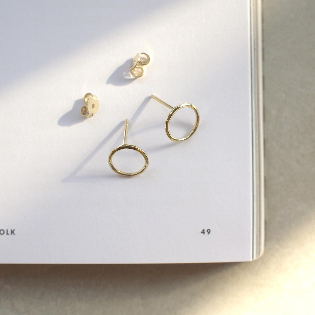 Brinco minimalista em forma de círculo vazado feito a mão em ouro 18k com textura martelada