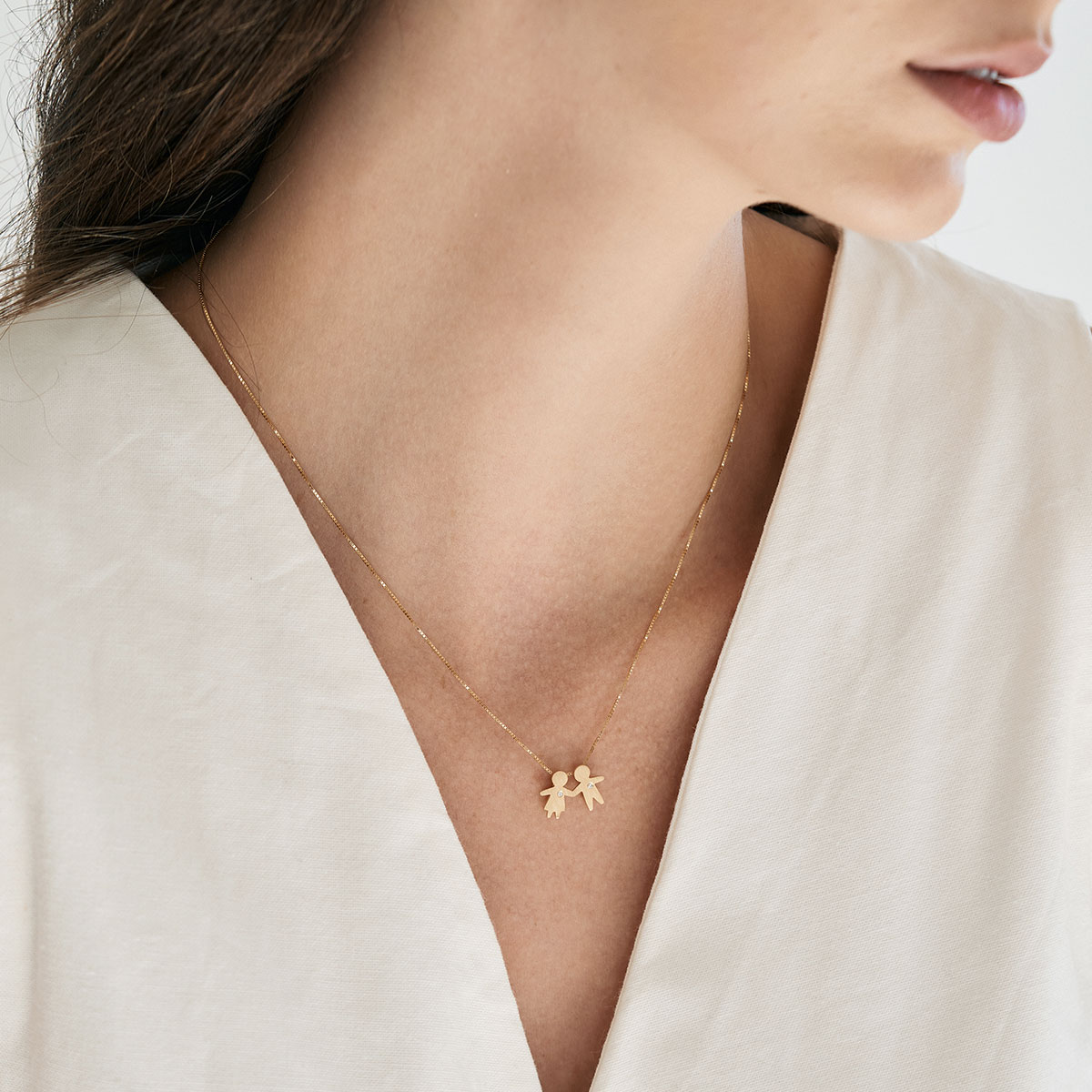 Mulher usando Pingente minimalista representando filhos feito a mão em ouro 18k com diamante