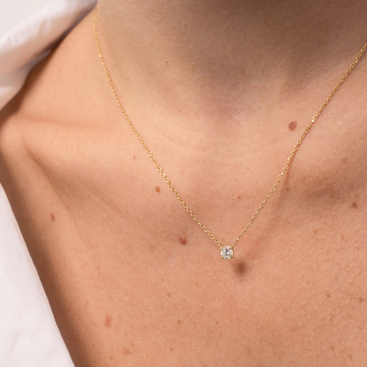 Mulher usando colar minimalista feito a mão em ouro 18k com diamante
