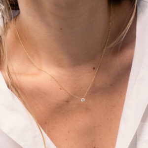 Mulher usando colar minimalista feito a mão em ouro 18k com diamante
