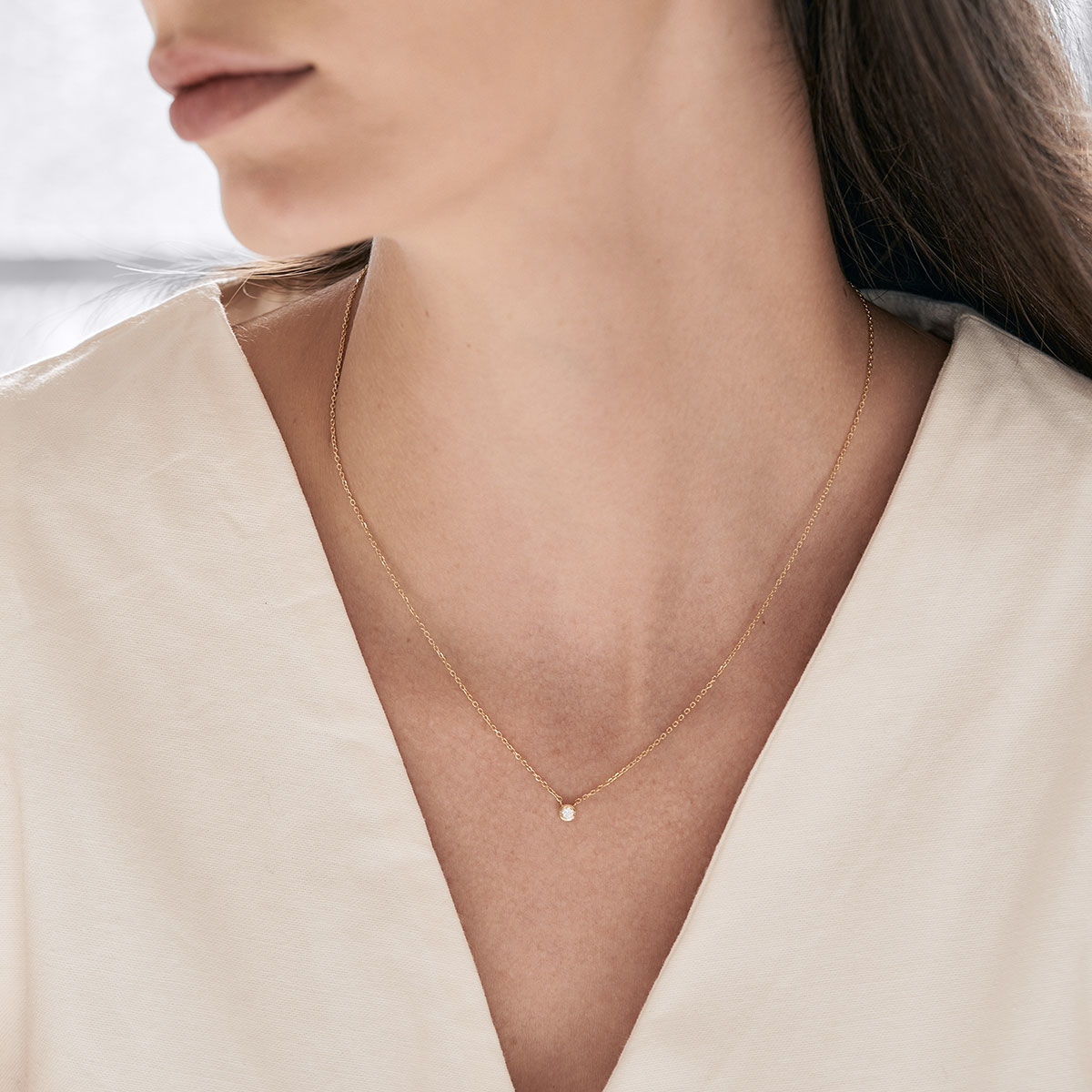 Mulher usando colar minimalista e delicado feito a mão em ouro 18k com diamante