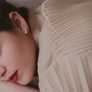 Mulher usando Brinco minimalista feito a mão em ouro 18k com quatro pérolas naturais em tamanhos diferentes