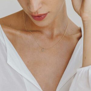 Mulher usando colar minimalista feito a mão em ouro 18k com letra da inicial do nome