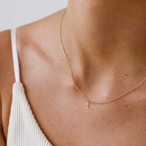 Mulher usando colar minimalista feito a mão em ouro 18k com letra da inicial do nome