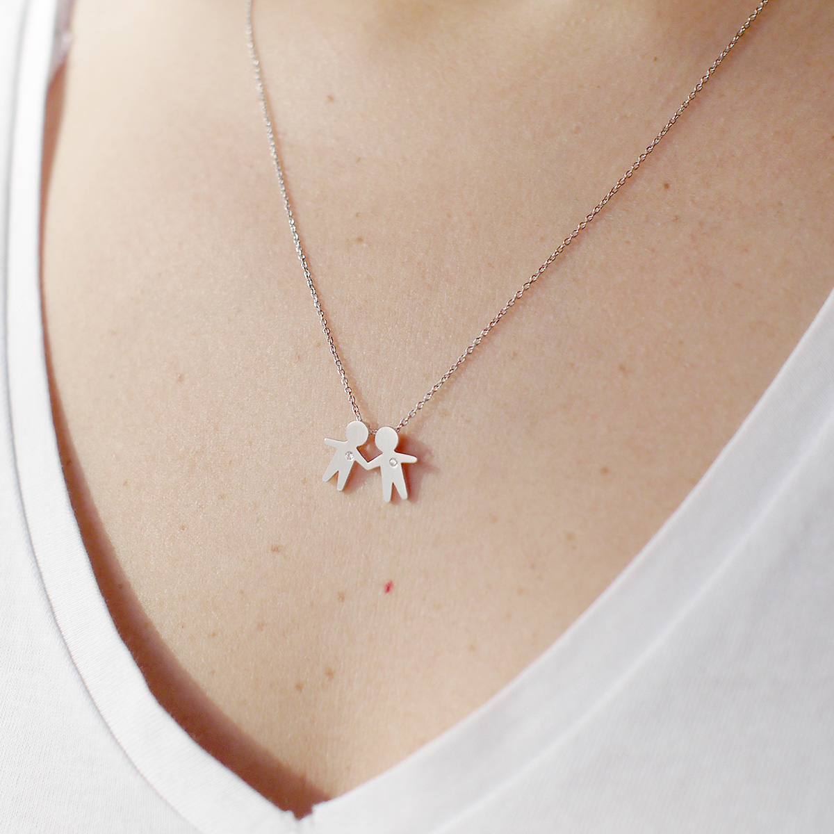 Mulher usando Pingente representando filhos juntos feito a mão em ouro 18k com diamante e corrente minimalista