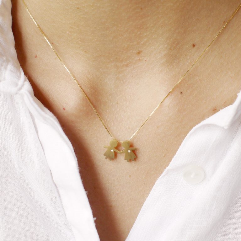 Mulher usando Pingente representando filhas juntas feito a mão em ouro 18k com diamante e corrente minimalista