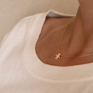 Mulher usando Pingente minimalista representando filho feito a mão em ouro 18k com diamante