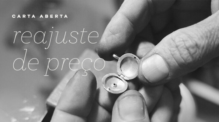 Imagem em preto e branco das mãos do ourives segurando um relicário de ouro 18k