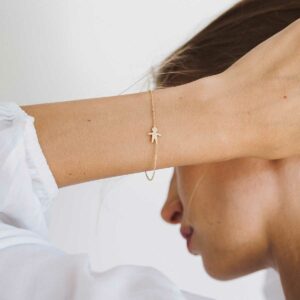 Mulher usando Pulseira minimalista representando filho feita a mão em ouro 18k com diamante e corrente cartier fina