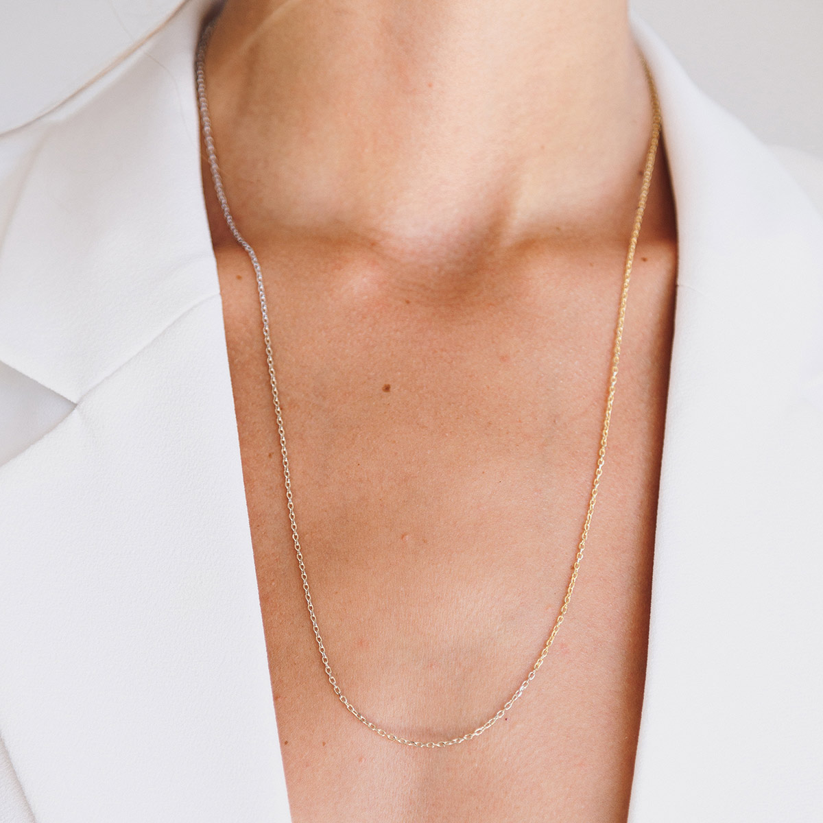Mulher com colete branco usando Corrente em degradê feita a mão em ouro amarelo, branco e champagne 18k
