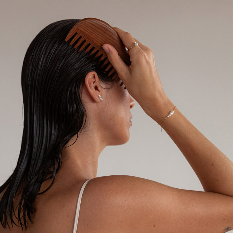 Mulher usando Pulseira, Colar e Brinco minimalistas feitos a mão em ouro 18k com pérolas naturais em tamanhos diferentes