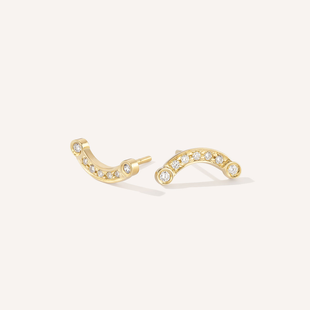 par de brincos em formato de semi círculo em ouro 18k amarelo e 7 diamantes em cada pé, sendo dois maiores e círculos nas extremidades e 5 menores acompanhando o formato de arco, sobre fundoo branco