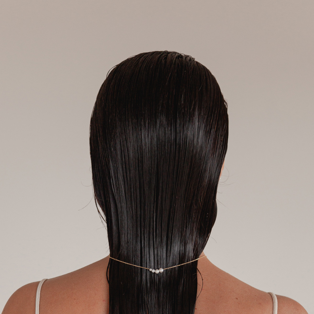 mulher usando colar minimalista feito a mão em ouro 18k de corrente fina e pérolas naturais de tamanhos diferentes