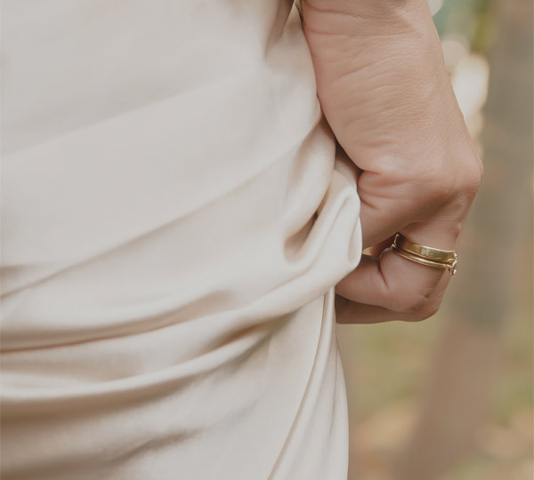 noiva usando aliança e anel minimalistas e delicados feitos à mão em ouro 18k com diamante para noivado e casamento