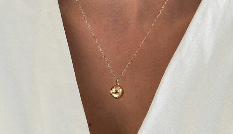 mulher usando colar relicário minimalista feito a mão em ouro 18k para colocar fotos