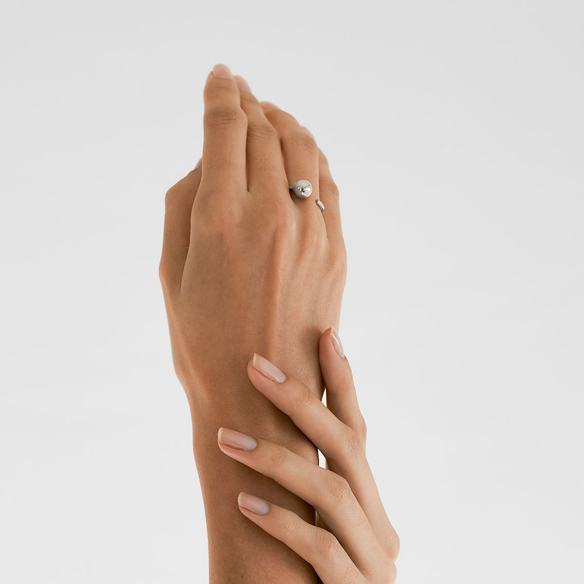 mulher usando anel minimalista feito a mão em ouro 18k com aro redondo e esfera