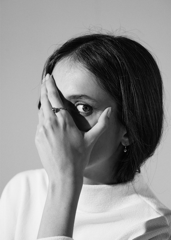 foto em preto e branco de mulher usando anel minimalista feito a mão em ouro 18k com aro redondo e esfera