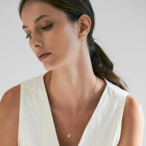 mulher usando colar e brinco de argola minimalista feito a mão em ouro 18k com esfera