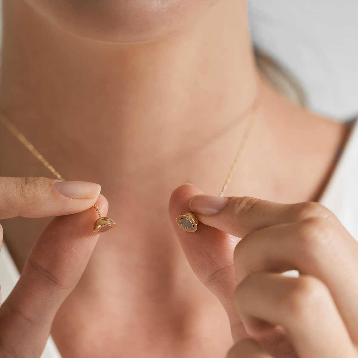 mulher usando colar minimalista feito a mão em ouro 18k com fecho magnético em formato de esfera