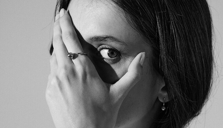 foto em preto e branco de mulher usando anel minimalista feito a mão em ouro 18k com aro redondo e esfera