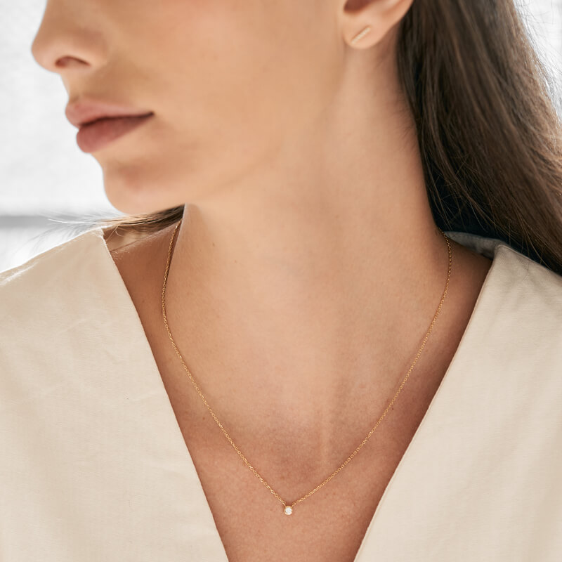 Mulher usando colar minimalista e delicado feito a mão em ouro 18k com diamante
