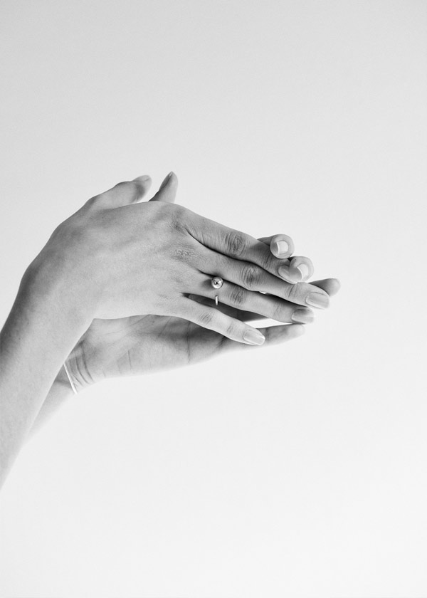 foto em preto e branco de mulher usando anel minimalista feito a mão em ouro 18k com aro redondo e esfera