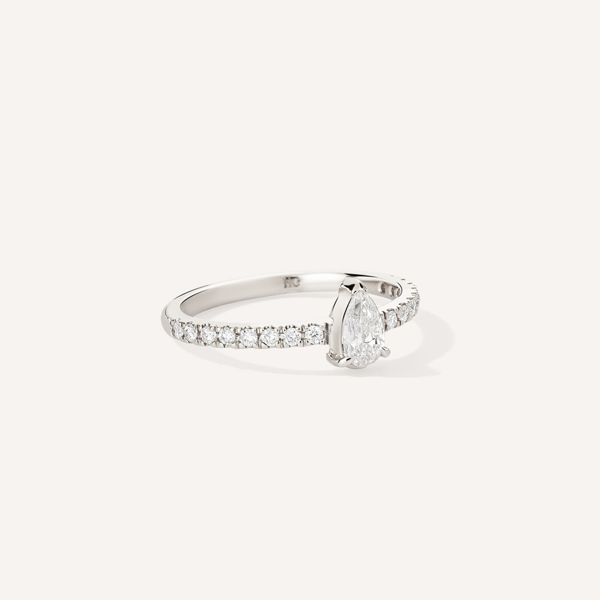 Anel de noivado feito à mão em ouro 18k com aro cravejado de diamantes e no centro um diamante em formato de gota