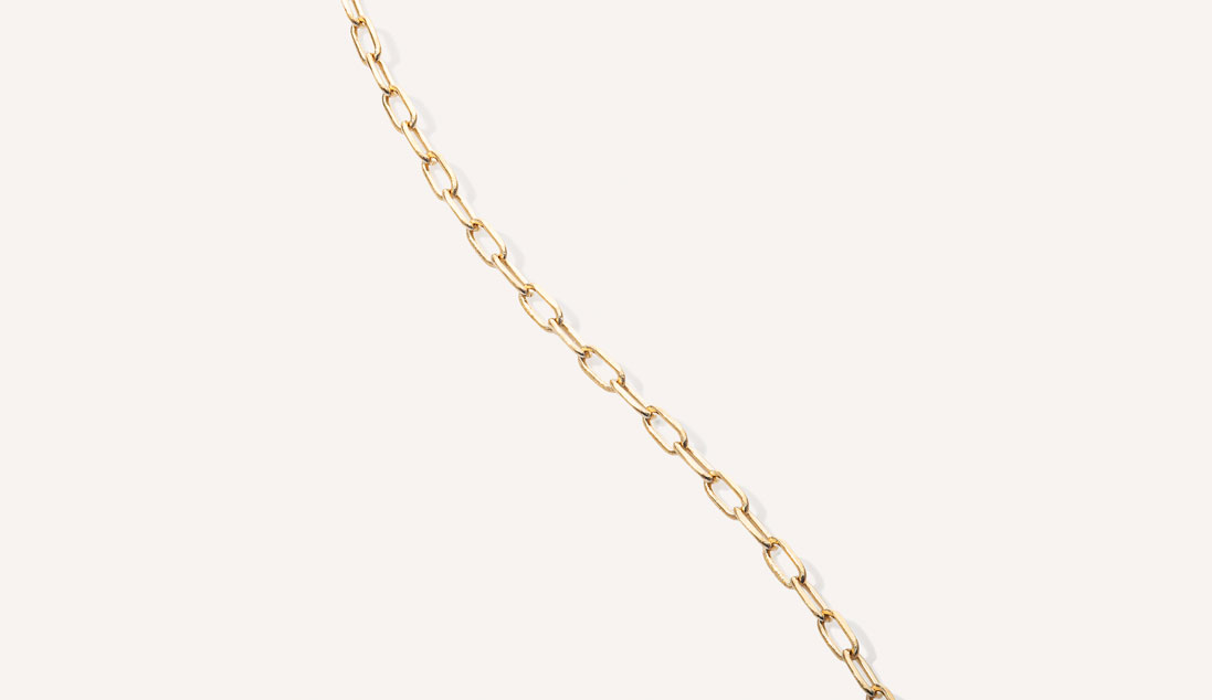 foto aproximada de corrente tipo cartier com elos longos em ouro 18k sobre fundo branco