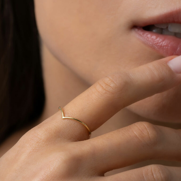 mulher usando anel de aro fino e minimalista com acabamento polido em ouro 18k em formato de bico V