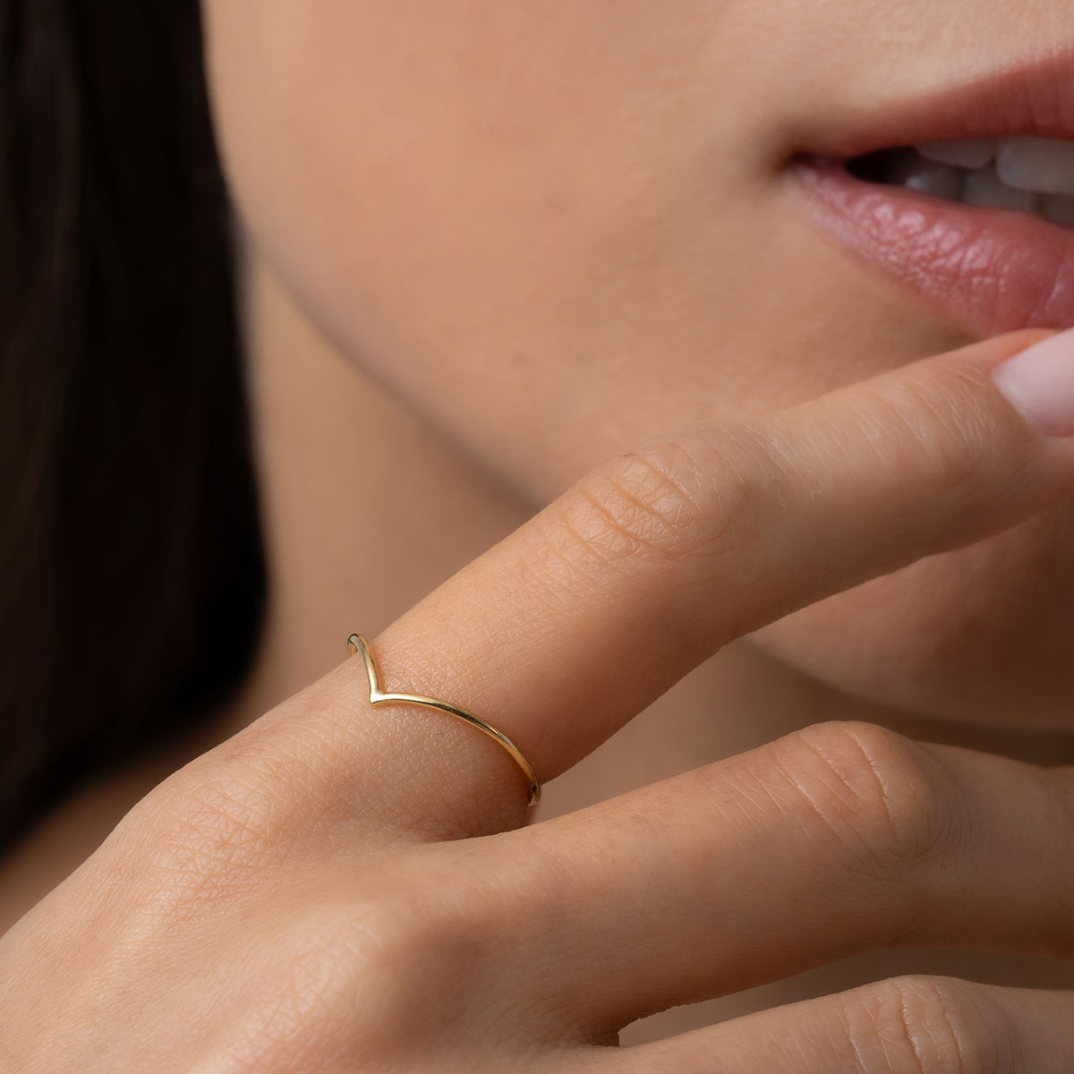 mulher usando anel de aro fino e minimalista com acabamento polido em ouro 18k em formato de bico V