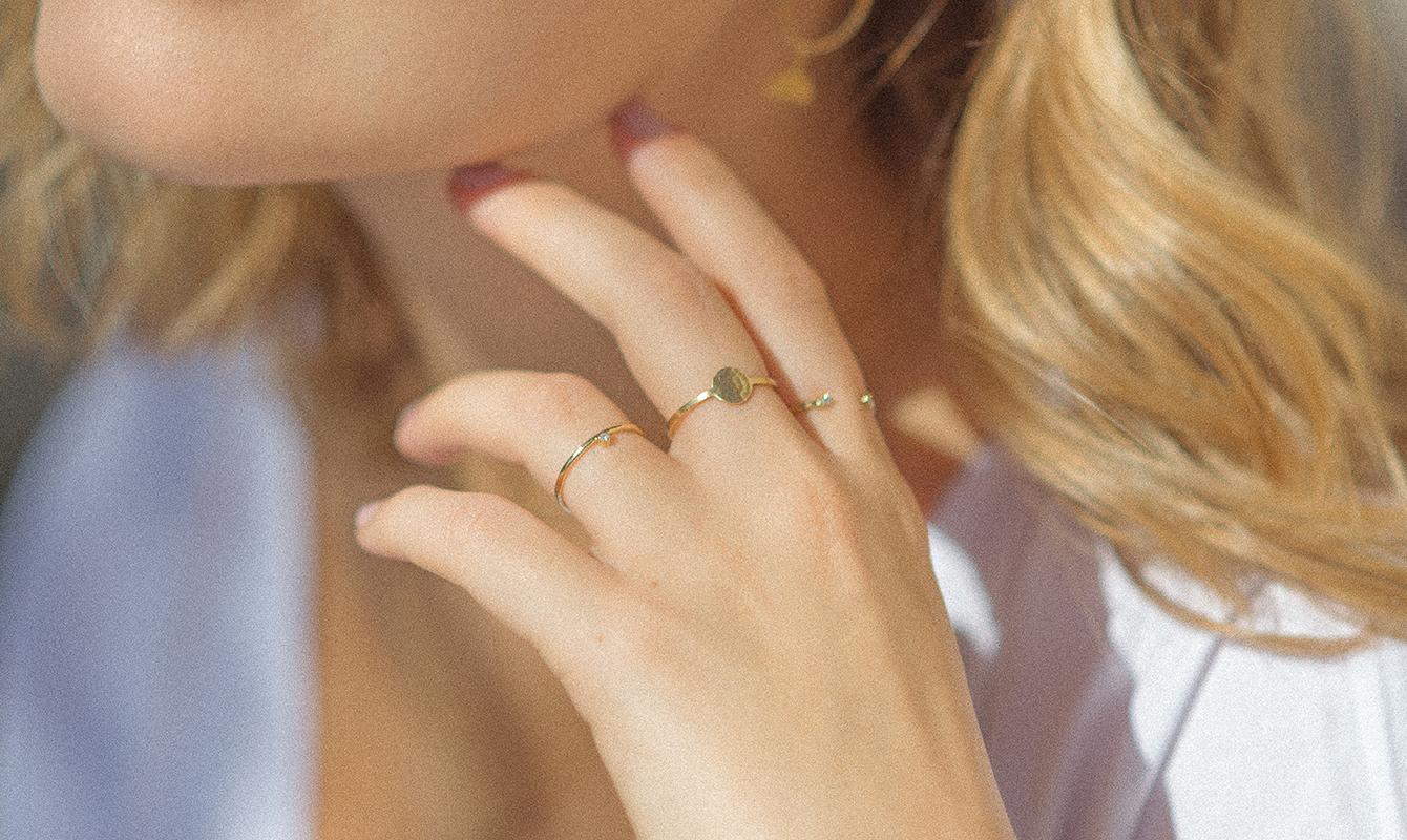mulher loira usando anéis feitos à mão em ouro amarelo 18k com diamantes