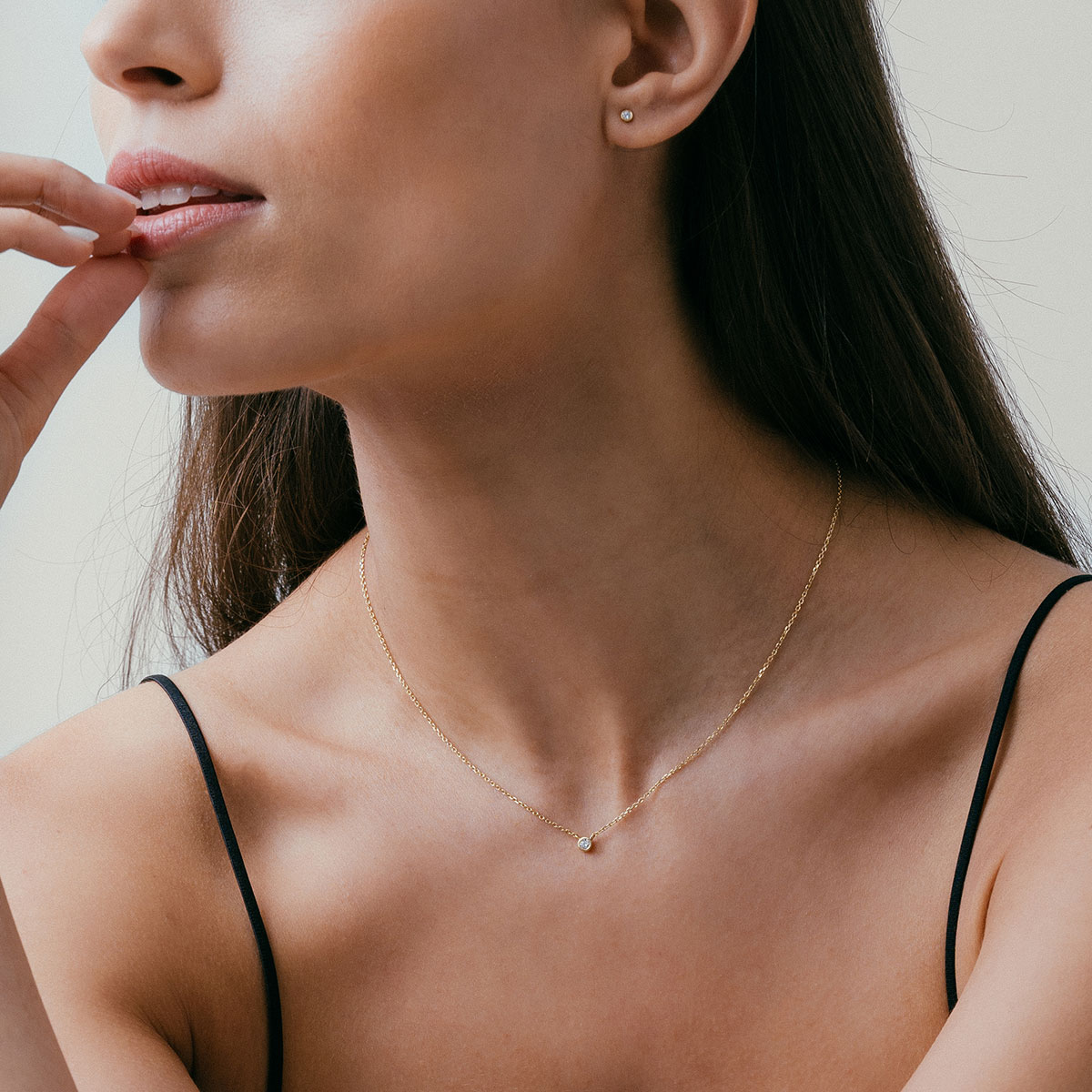 mulher usando colar minimalista e delicado feito à mão em ouro 18k com diamante ponto de luz central