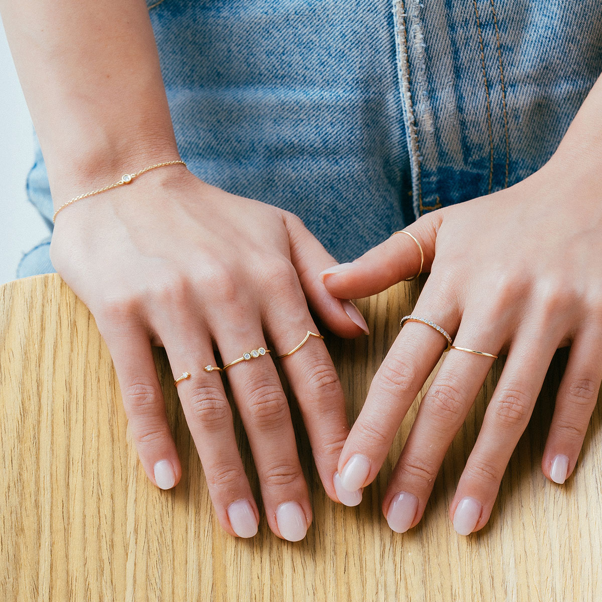 mulher usando anéis minimalistas feitos à mão em ouro 18k com diamantes