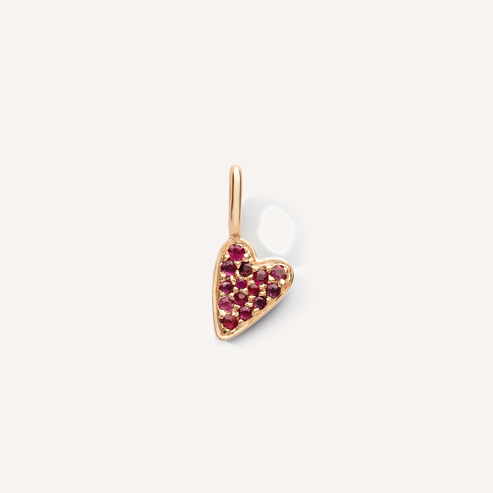 pingente em formato de coração em ouro 18k cravejado com 14 rubis vermelhos sobre fundo branco