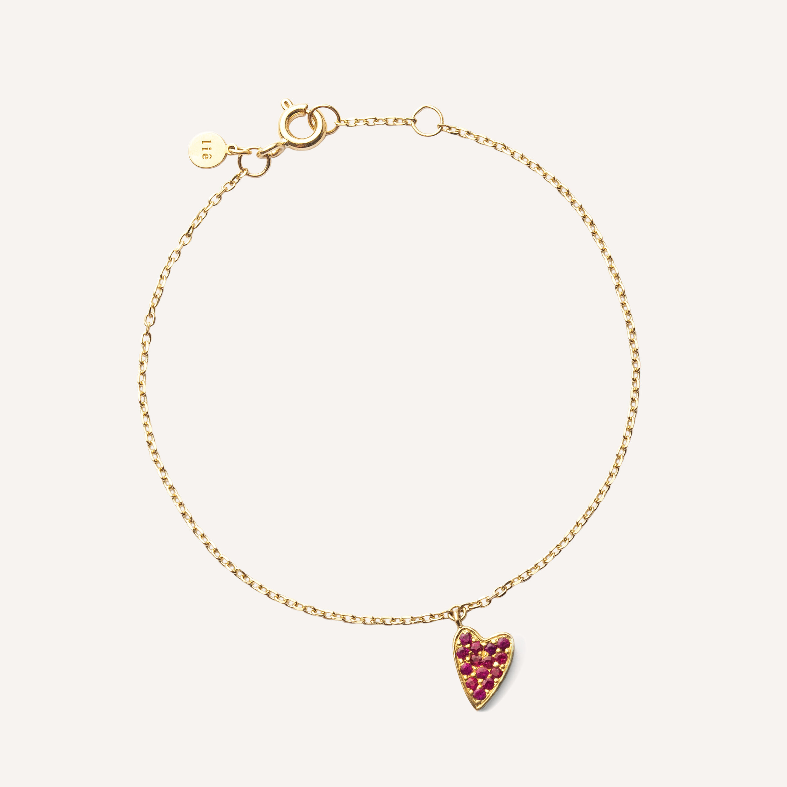 pulseira de ouro 18k com um pingente de coração cravejado com 14 rubis sobre fundo branco
