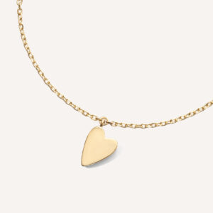 pulseira de ouro 18k com um pingente de coração sobre fundo branco
