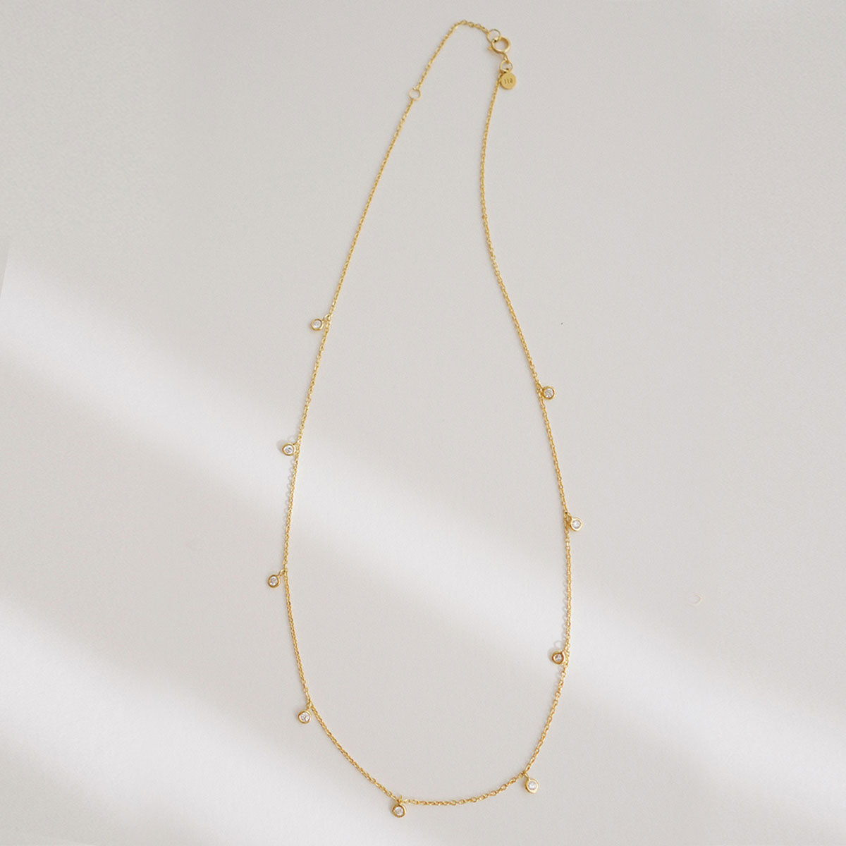 colar em ouro 18k com corrente tipo cartier e pingentes com diamantes de 0,03ct, sobre fundo branco