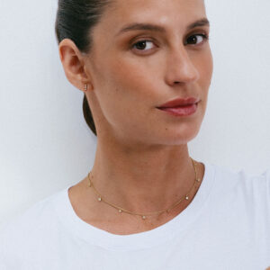 Colar curto e delicado em ouro 18k e diamantes vestido em modelo com camiseta branca