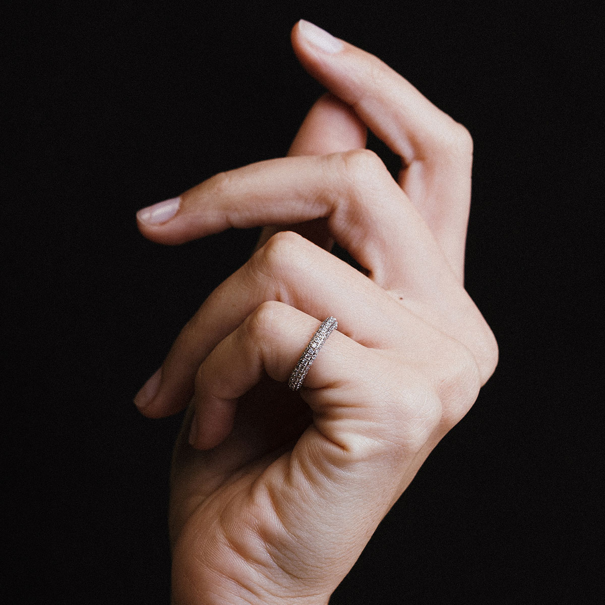 Mão feminina com o Anel Pinky Ring Diamantes Bombé em ouro 18k branco da Joias Liê em destaque.