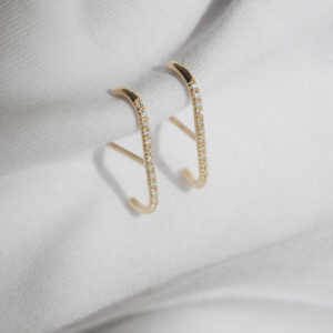 Fotografia still do Brinco traço em ouro amarelo 18k com diamantes, modelo delicado e curvado da Joias Liê, estilo ear cuff, que se encaixa no lóbulo.