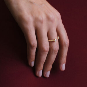 Mão usando anel aberto em ouro 18k com diamantes trillion e brilhante, joia minimalista da Joias Liê.