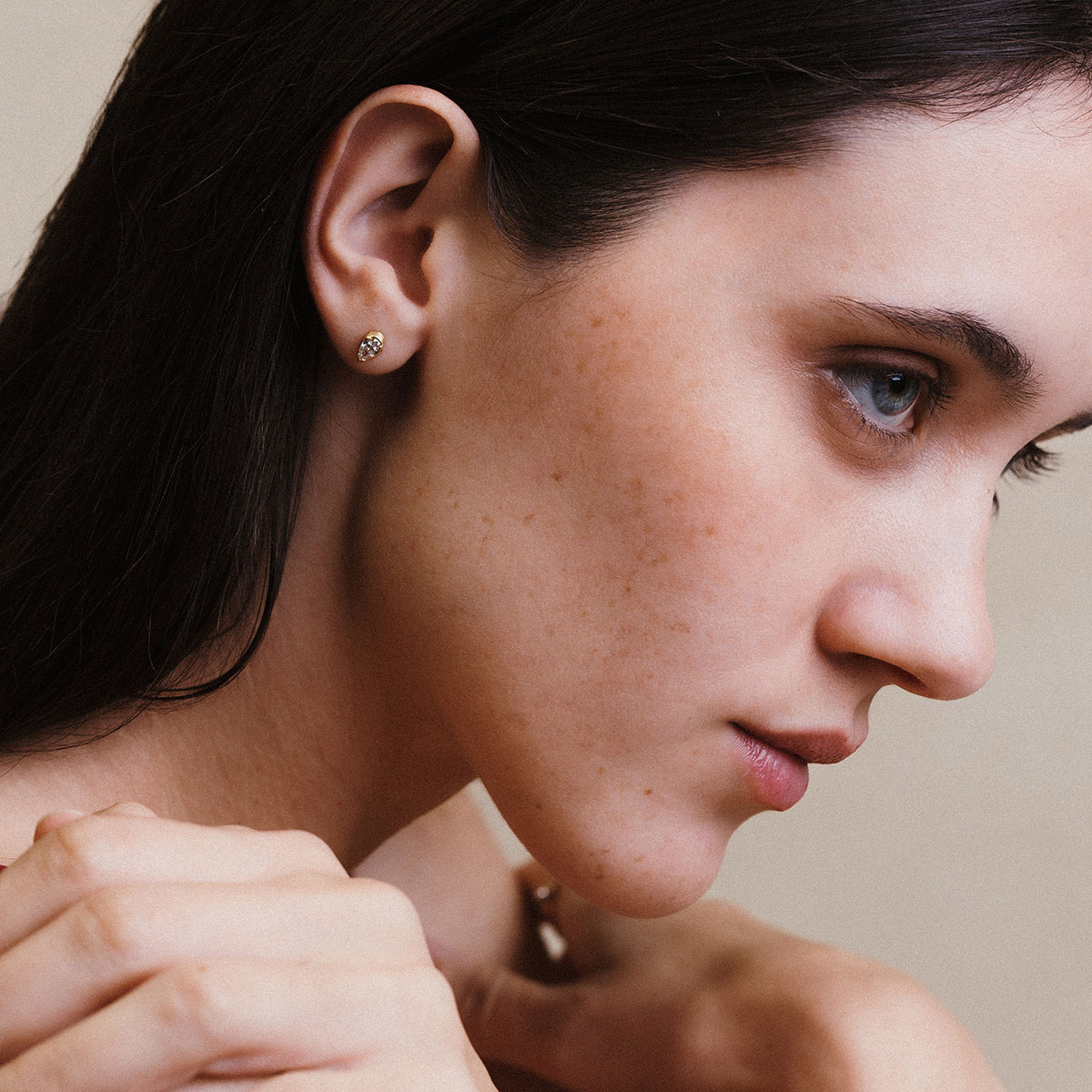 Mulher usando brinco de diamante em lapidação gota da Joias Liê, em ouro 18k.