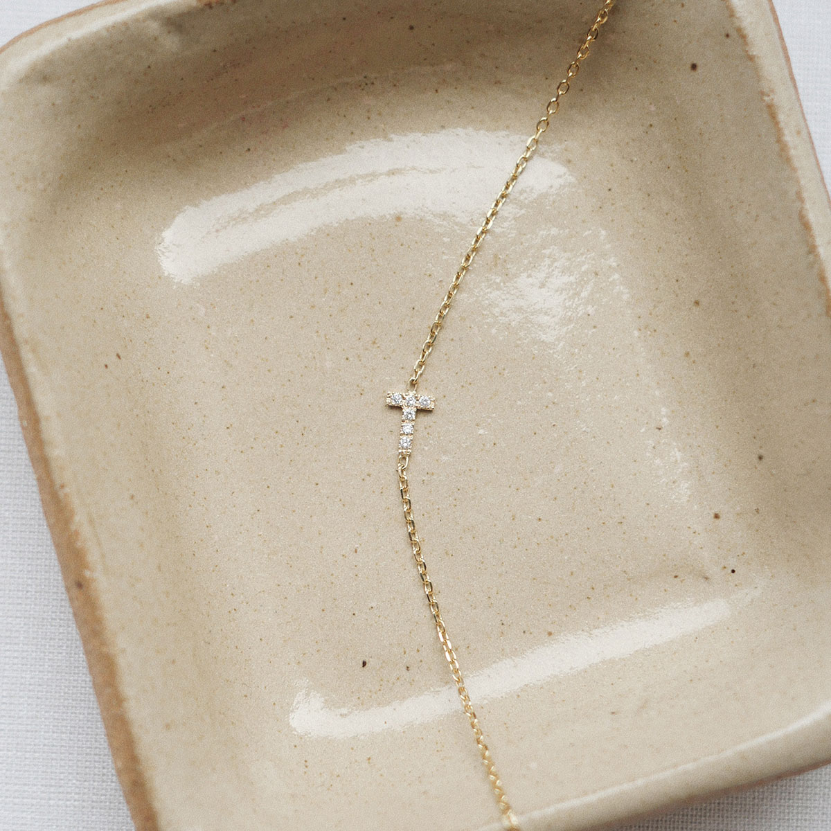 Pulseira de ouro 18k com inicial T cravejada com diamantes, da Joias Liê.
