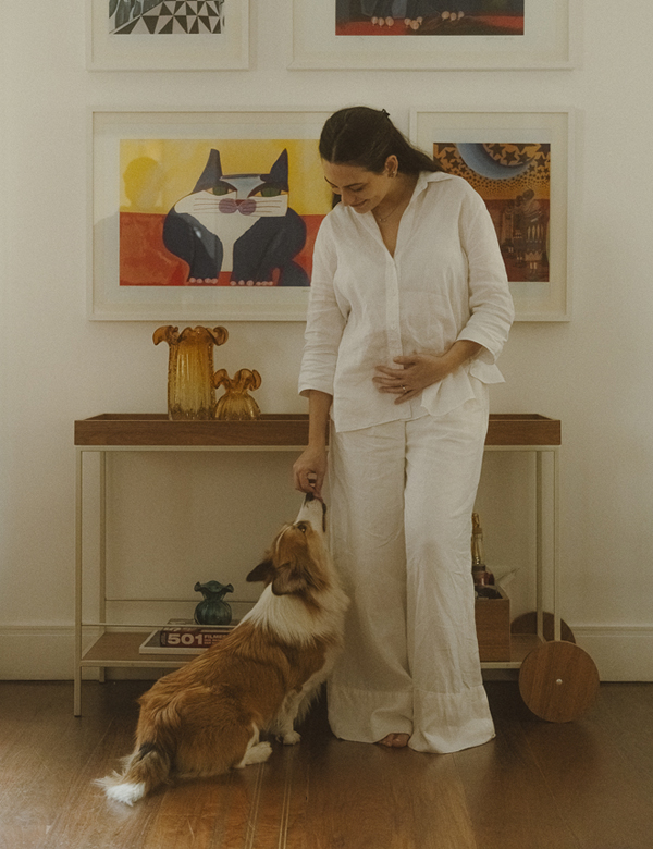 Natalia Maestrello interage com seu cachorro em casa, vestindo linho branco e joias Liê, em fotografia para a série “Em Camadas: uma série sobre propósito e autenticidade” no blog da Liê.