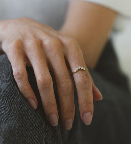 Mão de Rachel Bello com o Anel Drop Diamantes Liê, joia em ouro com design minimalista e elegante, em ensaio da série Em Camadas.
