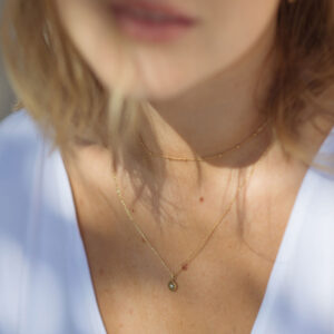 mulher usando uma corrente cartier slim fina em ouro amarelo 18k com pingente
