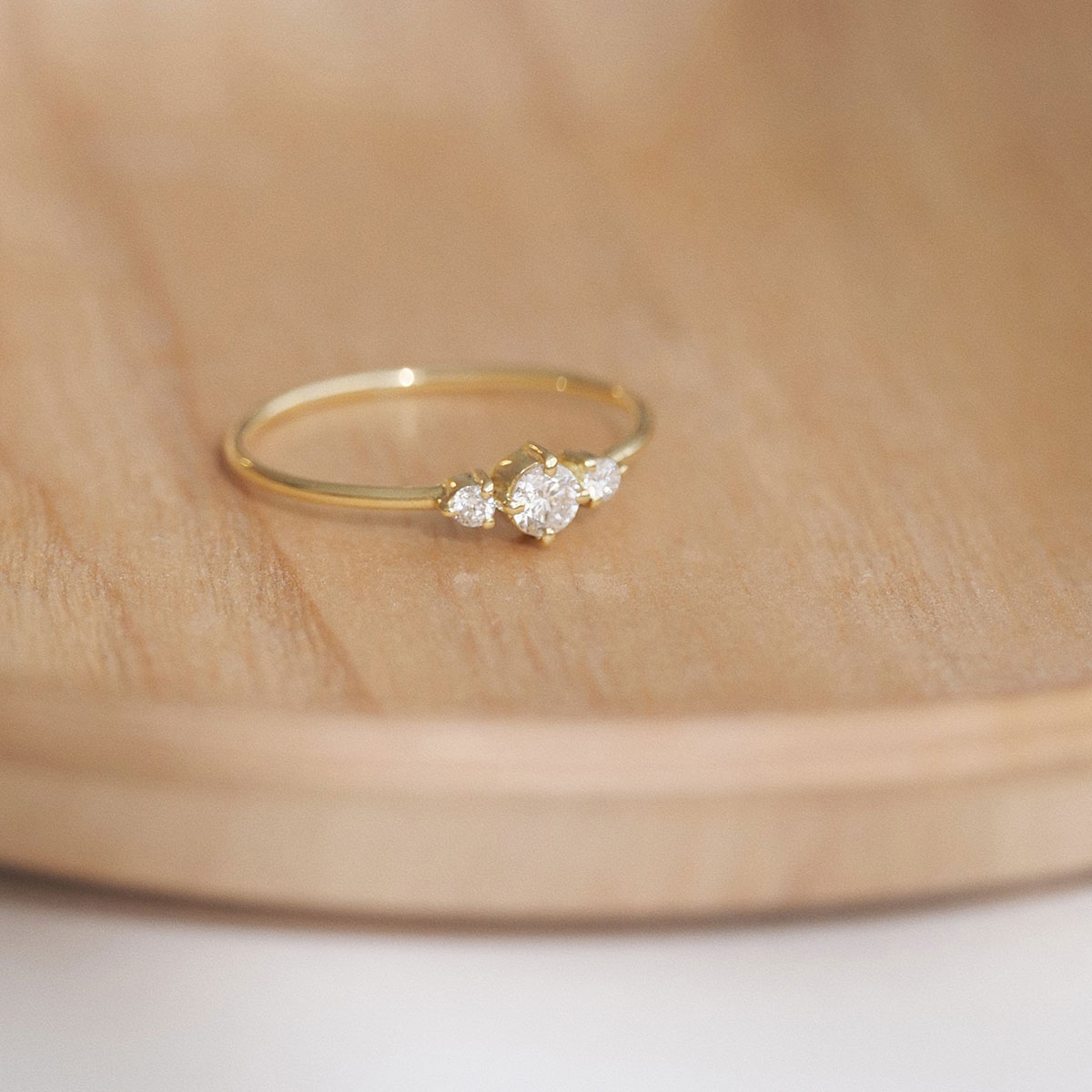 Anel minimalista em ouro 18k com um diamante central e dois diamantes laterais menores